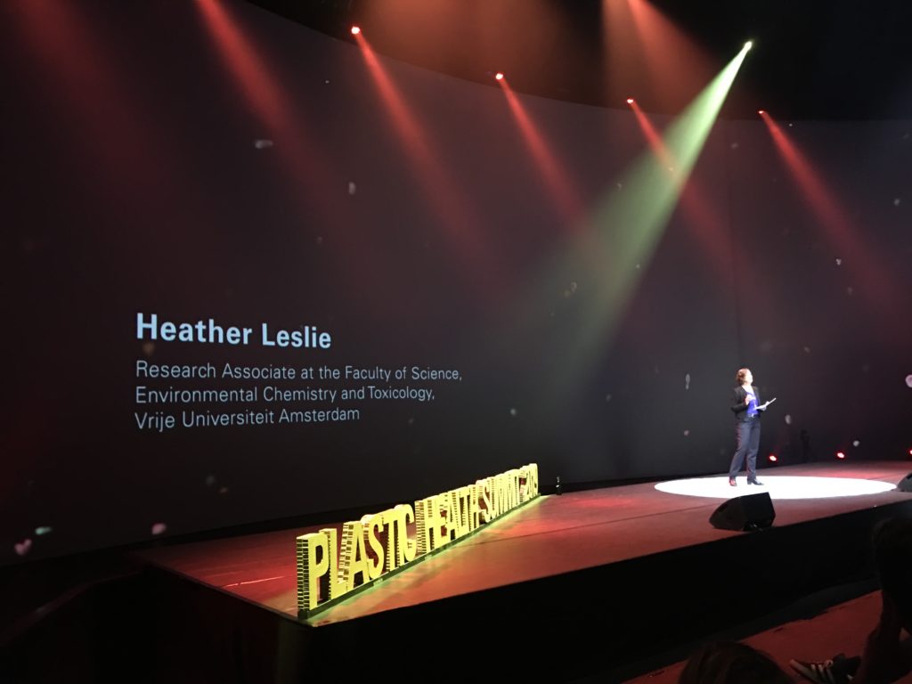 Een vrouwelijke wetenschappers geeft een presentatie op een groot podium